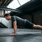 Pratiquant enchainant un drop set avec des halteres de charges decroissantes en salle de musculation
